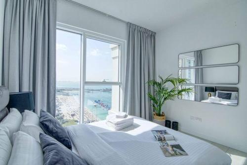 een slaapkamer met een groot bed en een groot raam bij Stunning 2BR with Sea and Ain Dubai View at JBR in Dubai