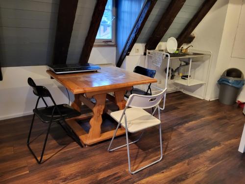 einen Tisch und Stühle mit einem Laptop darüber in der Unterkunft Fachwerk Maisonette in Nürtingen in Nürtingen