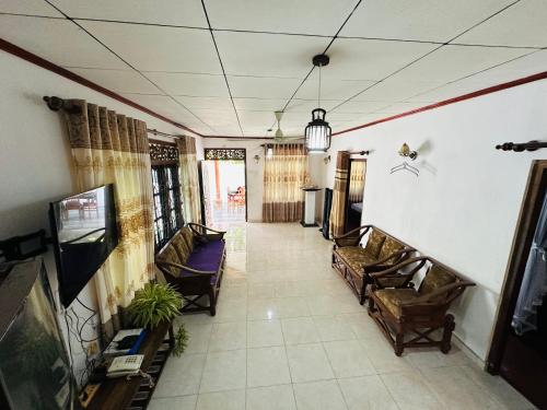 a hallway with couches and a tv in a room at Pahasara Villa in Mirissa