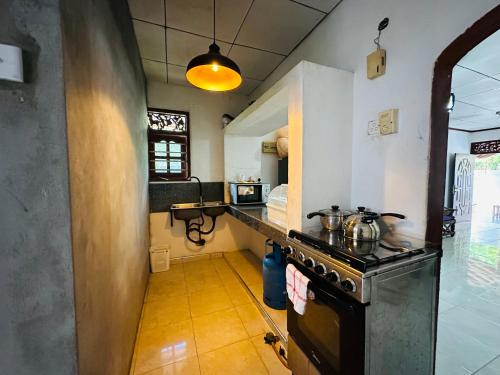 a kitchen with a stove and a counter top at Pahasara Villa in Mirissa