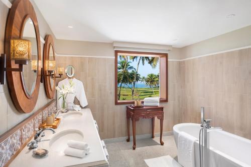 a bathroom with a tub and a sink and a bath tub at Taj Exotica Resort & Spa, Goa in Benaulim