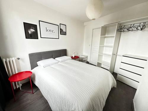 a bedroom with a white bed and a red stool at Le Gentil Rooftop in Gentilly