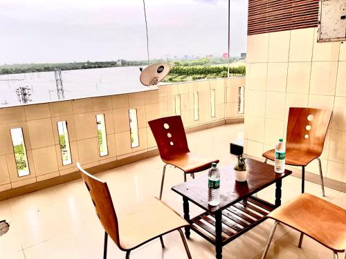HOTEL SITA GRAND في شامشاباد: طاولة وكراسي في غرفة مع نافذة كبيرة