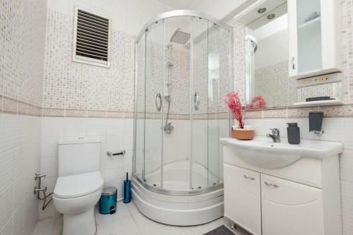 La salle de bains est pourvue d'une douche, de toilettes et d'un lavabo. dans l'établissement Cosy Urban 2-Bedroom Apartment, à Istanbul
