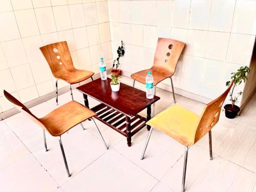 HOTEL SITA GRAND في شامشاباد: طاولة وكراسي عليها زجاجات ماء