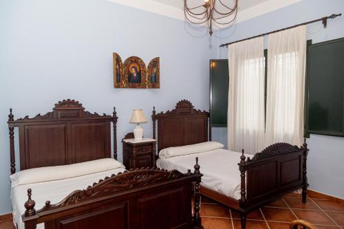 una camera da letto con due letti e un tavolo con una lampada di Finca Los Majadales ad Almodóvar del Río