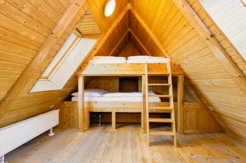 a room with two bunk beds in a wooden attic at Hotel Leyla in Frymburk
