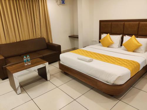 a hotel room with a bed and a couch at Relax Inn in Bengaluru
