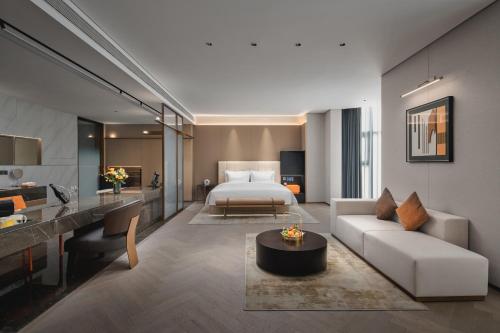 a hotel room with a bed and a living room at voco Xi'an Qindu Legend, an IHG Hotel in Xi'an