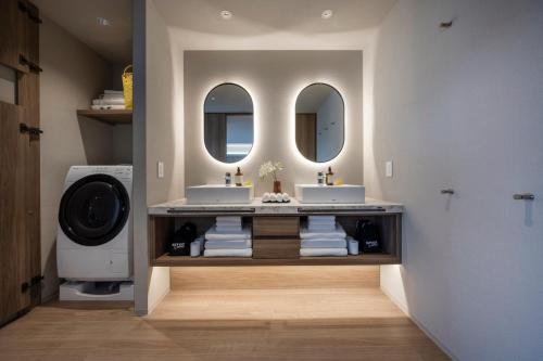 a bathroom with two sinks and two mirrors at seven x seven Itoshima in Itoshima