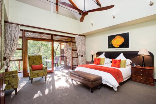 una camera da letto con un grande letto con un piumone rosso di Irene Country Lodge, Autograph Collection a Centurion