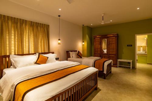 una camera d'albergo con due letti e uno specchio di Makayiram Retreat a Munnar