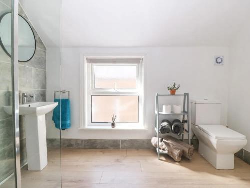 a bathroom with a toilet sink and a window at 'Llandudno Central' - 2 Bed Luxury Flat, Close to Town and Beaches in Llandudno