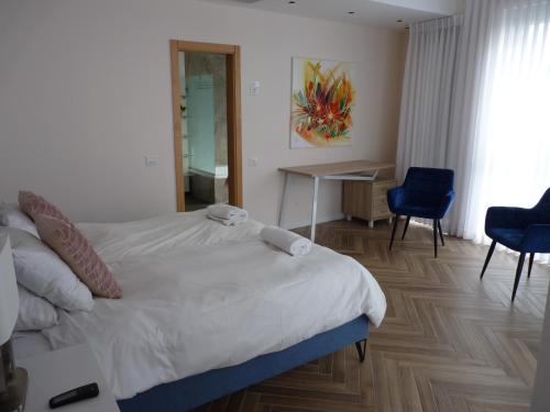 a bedroom with a bed and a table and chairs at JTower Royal Suites - The Penthouse - Alefimmoed in Jerusalem
