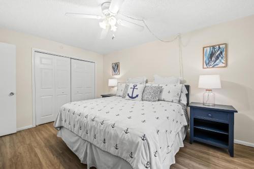 a bedroom with a bed and a ceiling fan at Coconuts Poolside #115 in Holmes Beach