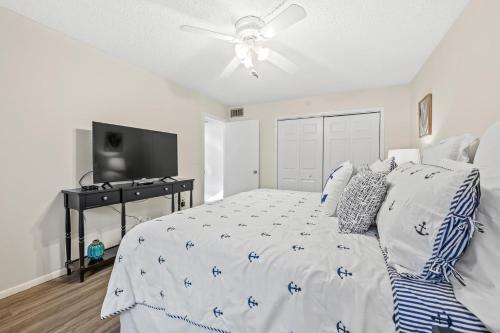 a bedroom with a bed and a ceiling fan at Coconuts Poolside #115 in Holmes Beach