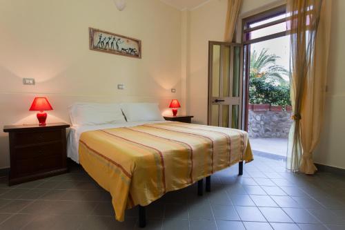 a bedroom with a bed and a sliding glass door at Casa Cosmano in Brancaleone Marina