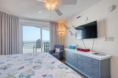 a bedroom with a bed and a tv and a window at 2501 S Ocean Blvd, 1031 - Ocean View Sleeps 8 in Myrtle Beach