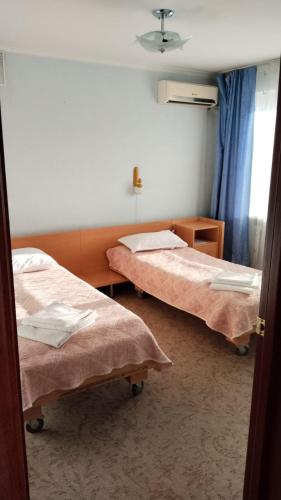 a hospital room with two beds and a window at Tumar Apart Hotel in Karagandy