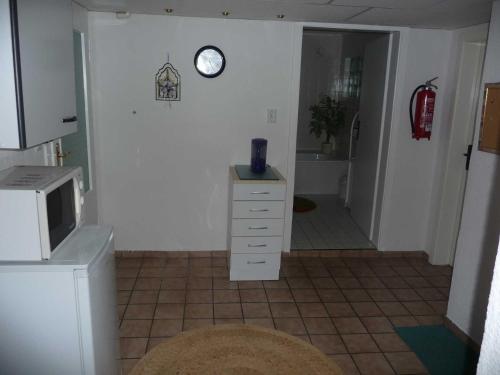 a kitchen with a clock on the wall and a dresser at Ferienwohnung DZ Blesse Allstedt in Allstedt