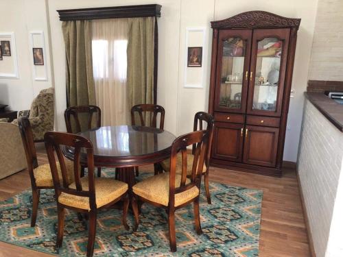 Magawish Villa hurghada في الغردقة: غرفة طعام مع طاولة وكراسي وخزانة