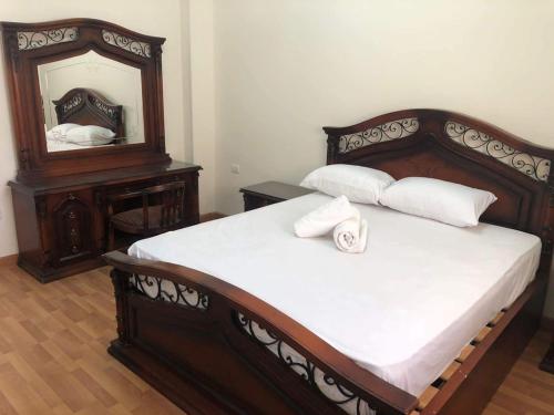 Magawish Villa hurghada في الغردقة: غرفة نوم مع سرير خشبي كبير مع مرآة
