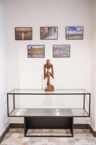 a statue sitting on a glass table in front of a wall with pictures at Apartamenty Parkowa 9 in Lesko