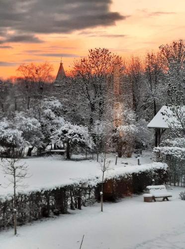 a park covered in snow with a sunset in the background at Lesse en Ciel vous accueille avec plaisir . in Houyet