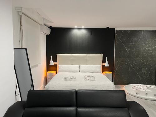 a black and white bedroom with a bed and a black wall at H Pelayo Auto Check-In Rooms in Noja