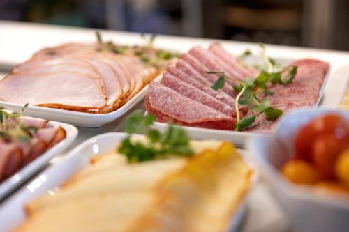 a table topped with different types of food on plates at Hotell Skövde in Skövde