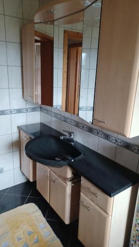 a bathroom with a black sink and a mirror at Ferienwohnung Haus am Berg in Innernzell