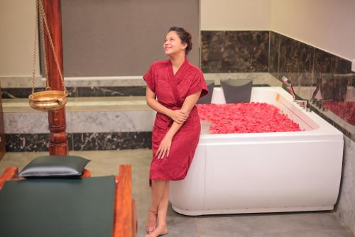 a woman standing next to a tub filled with roses at Softouch Ayurveda Village Kerala in Kizhake Chālakudi
