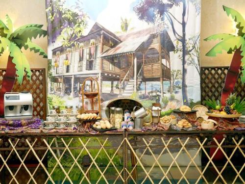 a table with food and a mural of a house w obiekcie Le Seaview PortDickson w mieście Port Dickson