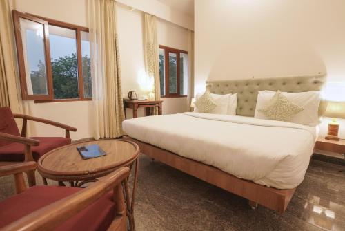 a hotel room with a large bed and a table at The Chitvan Resort in Ajmer