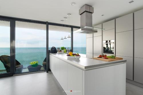 a kitchen with a view of the ocean at Luxusferienhaus Cube23 in Olpenitz