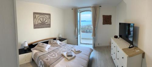1 dormitorio con 1 cama grande y TV en La Maison Bleue à 2 pas du Lac du Neuchâtel, en Hauterive