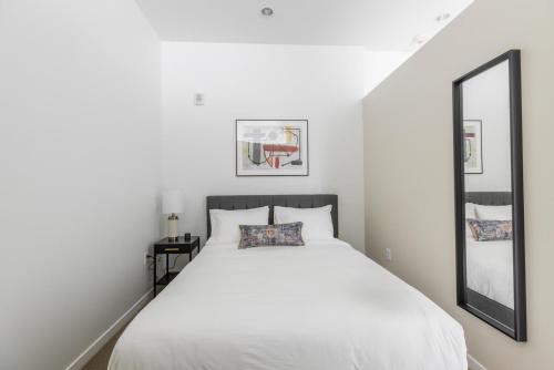 a bedroom with a white bed and a mirror at Downtown studio w gym laundry nr shopping BOS-987 in Boston