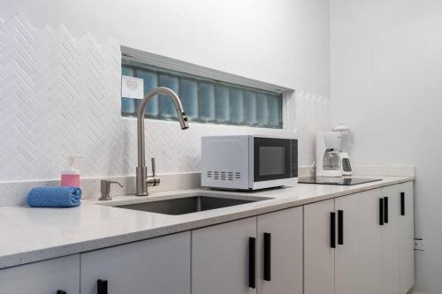 een keuken met een spoelbak en een magnetron bij Media Luna Studio Oceanview Pool in San Juan
