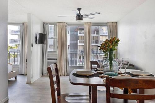 een eetkamer met een tafel met een vaas met bloemen bij Media Luna Studio Oceanview Pool in San Juan