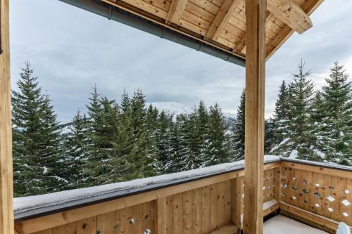 a view from the deck of a cabin with snow covered trees at Bergchalet "Haus Sonja" in Katschberghöhe