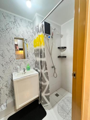 a white bathroom with a sink and a shower at Studio Unit-8 Spatial Condo in Davao City