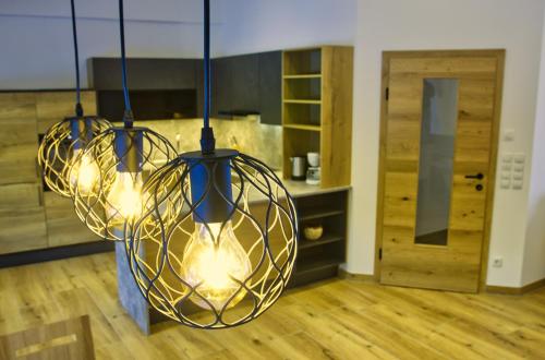 two lights hanging in a room with a wooden floor at Tonibauer in Tamsweg