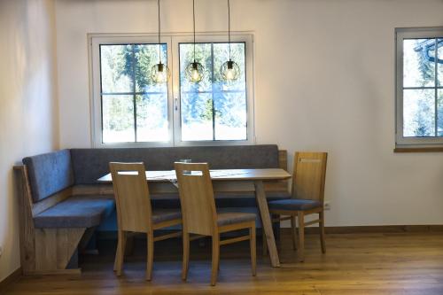 a dining room table with four chairs and two windows at Tonibauer in Tamsweg