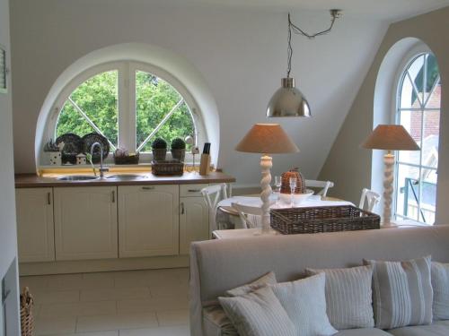 ein Wohnzimmer mit einem Sofa und eine Küche mit zwei Fenstern in der Unterkunft Godeke Michels Ferienwohnung 35Susewind Müggenburger Weg 40 in Zingst