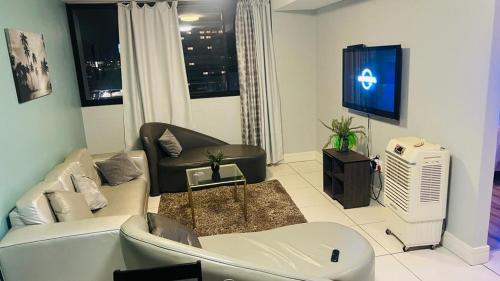 uma sala de estar com um sofá e uma televisão em Windhoek City Center self catering appartment em Windhoek