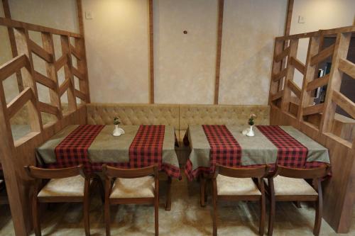 Alwaye的住宿－HOTEL VKJ INN Aluva，两个桌子,两个椅子,桌子,西德西德