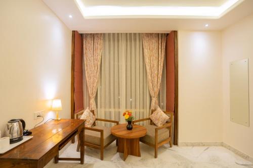 a hotel room with a desk and chairs and a table at The Chitvan Resort in Ajmer
