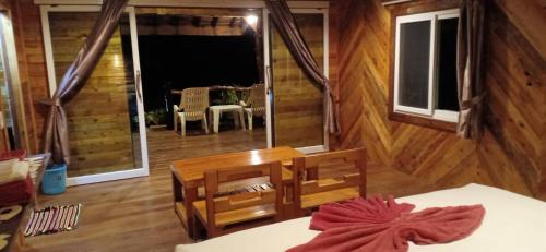 Habitación con cabaña de madera, cama y mesa. en Koh Jum Freeda Resort, en Ko Jum