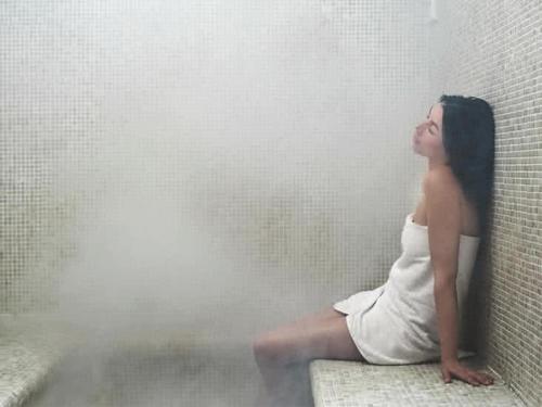 a woman in a white dress sitting on a wall at Edition Old City Hotel in Istanbul