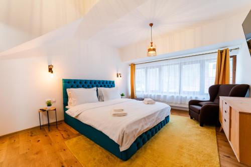 a bedroom with a large bed with a blue headboard at Carpe Diem in Bran